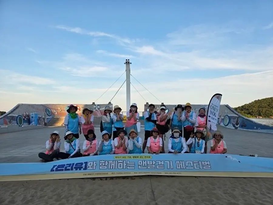 I membri della comunità di residenti Only You posano per una foto ricordo al festival della camminata a piedi nudi dello scorso anno, al lido di Ilgwang (Foto: Corporazione per la gestione urbana della contea di Gijang)